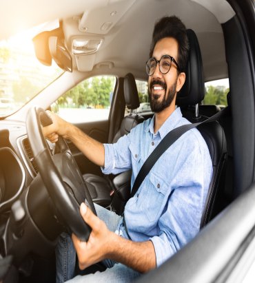 happy-millennial-eastern-guy-driving-nice-auto-sun-flare (1)